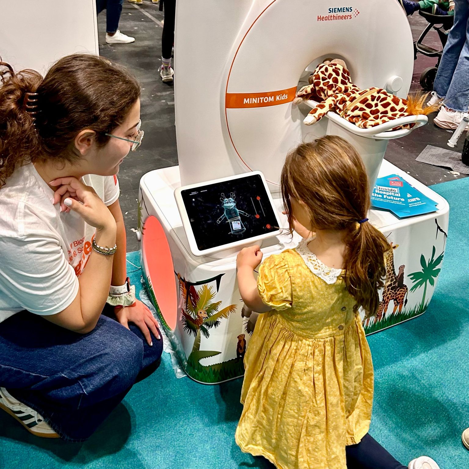 Adriana helping a young visitor explore a toy medical scanner at New Scientist Live